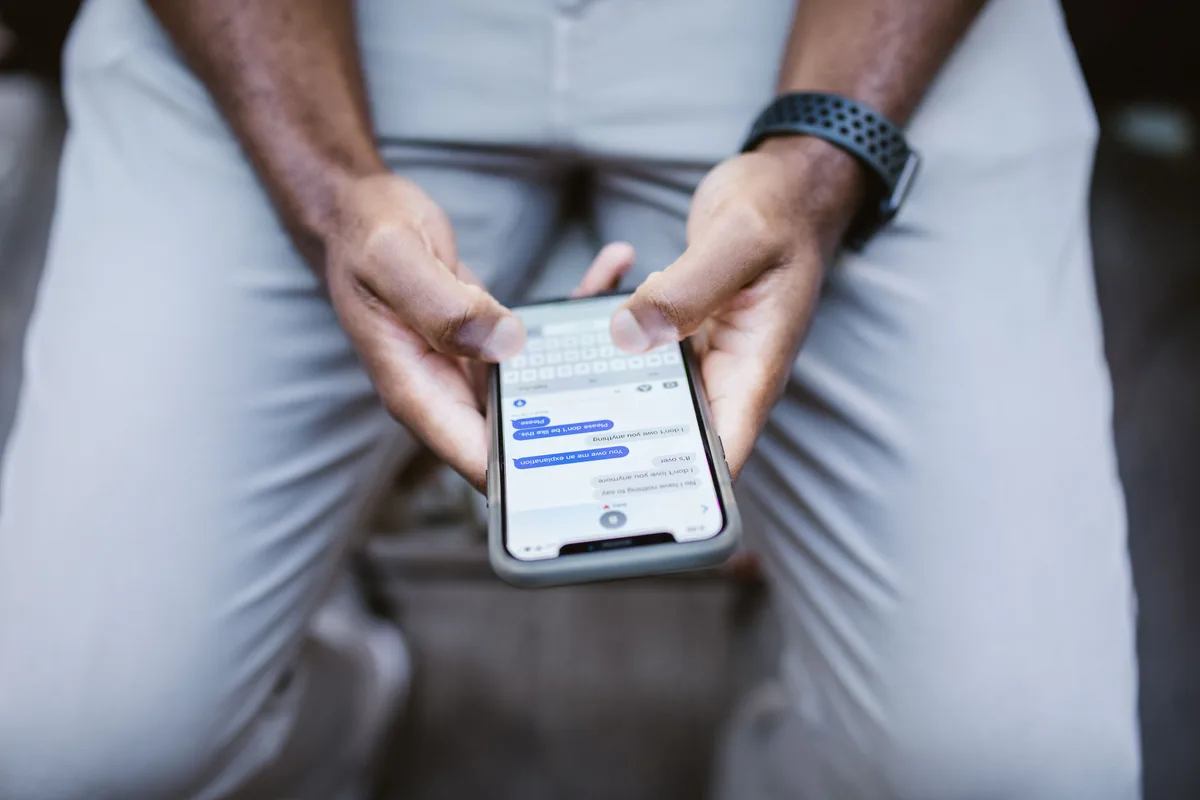 Close-up of a person typing a message on a smartphone, representing the Telegram idea-intake step
